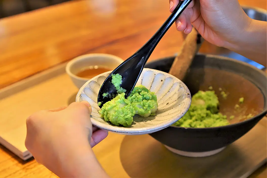 出来立てのずんだを、つやつやのお餅にからめる。