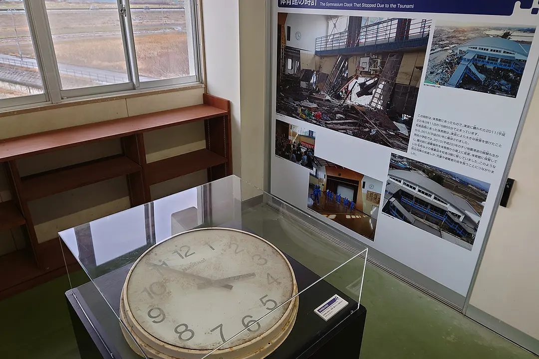 津波よって大きな被害を受け解体された体育館に架けられていた時計は、津波が到達した時間の午後3時55分を示して止まっている。