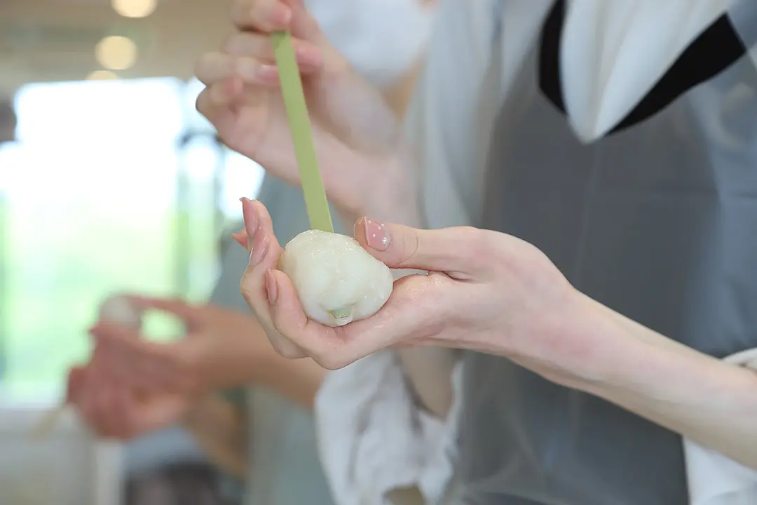 こねたすり身を串に刺して、型に入れてかたちを整える