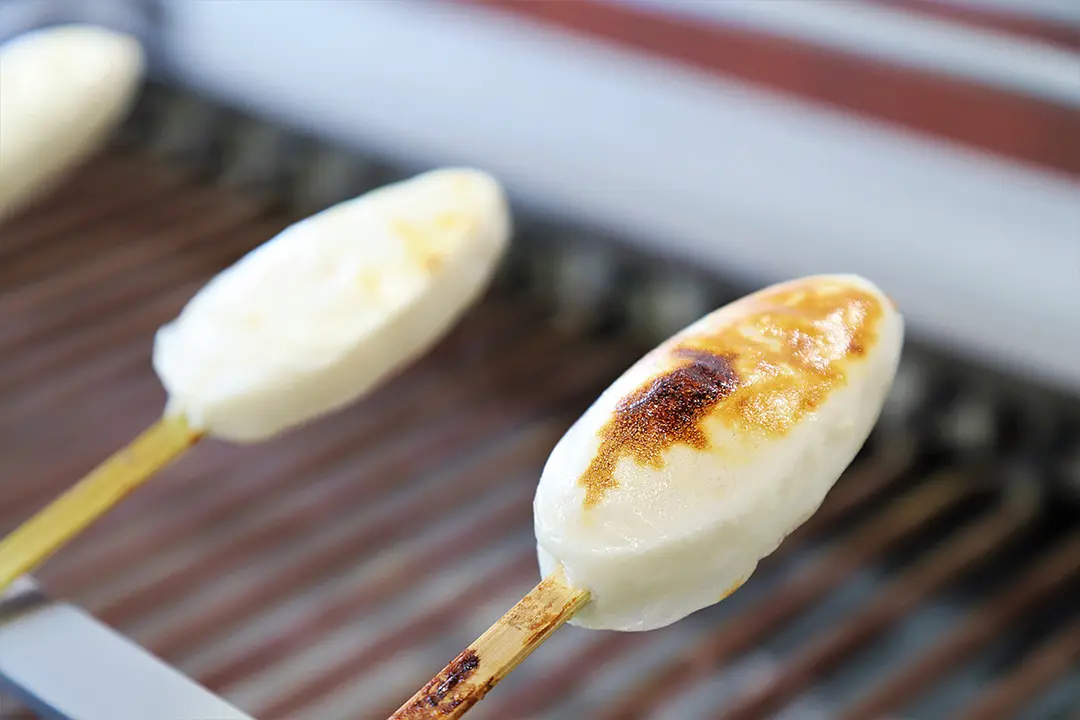 こねたすり身を串に刺して、型に入れてかたちを整える